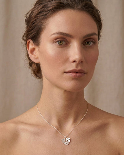 Γυναίκα που φοράει το ασημένιο κολιέ Curved Heart της ANV Jewelry από ανακυκλωμένο ασήμι 925, με το σχέδιο της καρδιάς να συμβολίζει την αγάπη και τον συναισθηματικό δεσμό.