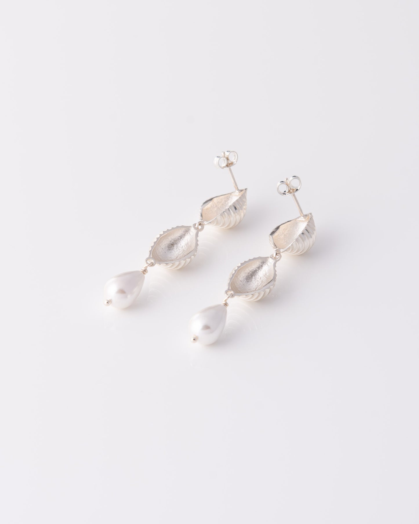 Minimal chic κρεμαστά σκουλαρίκια Pa Shell Pearl Drop Silver με κομψό σχεδιασμό εμπνευσμένο από τη θάλασσα της ANV Jewelry.