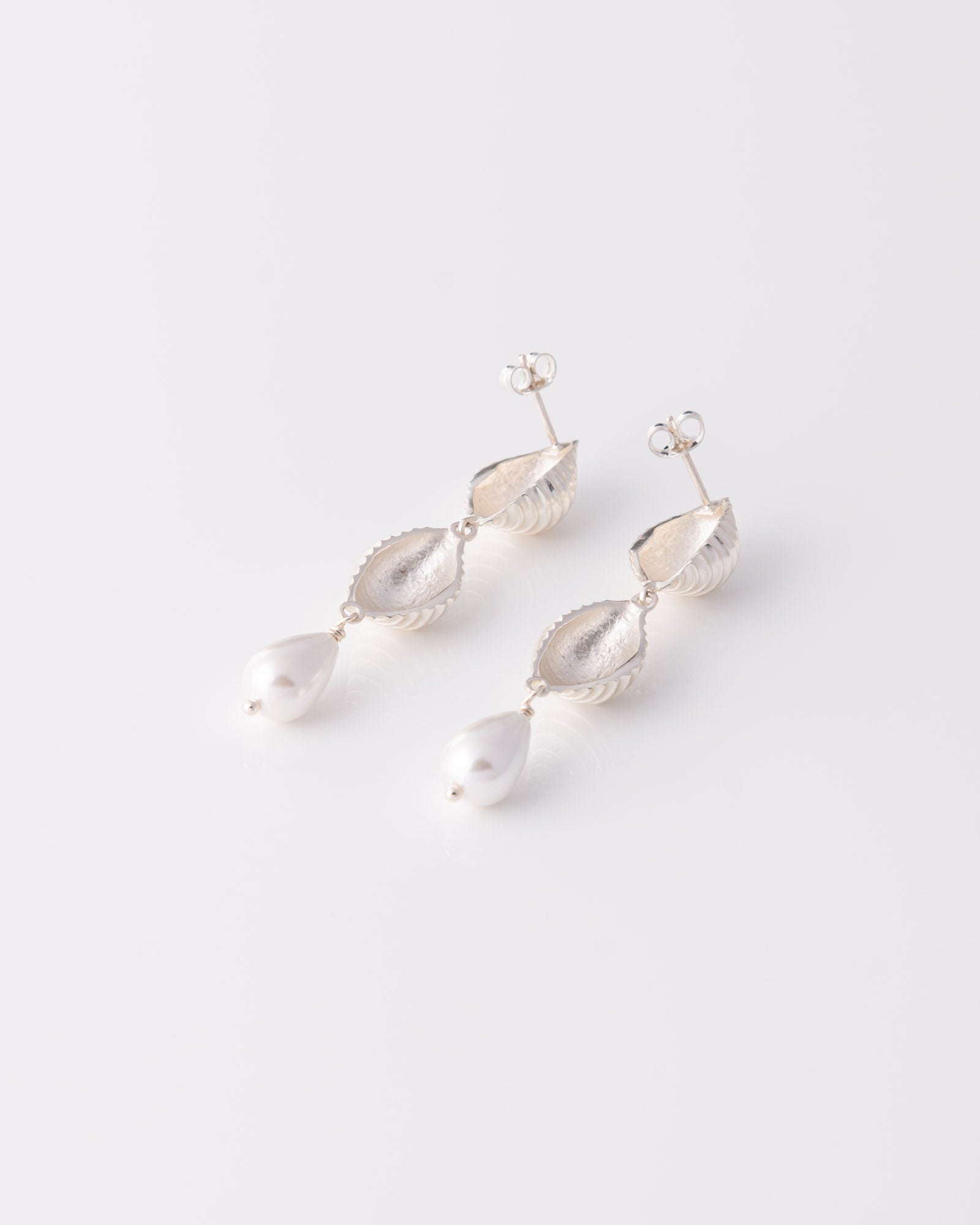 Minimal chic κρεμαστά σκουλαρίκια Pa Shell Pearl Drop Silver με κομψό σχεδιασμό εμπνευσμένο από τη θάλασσα της ANV Jewelry.