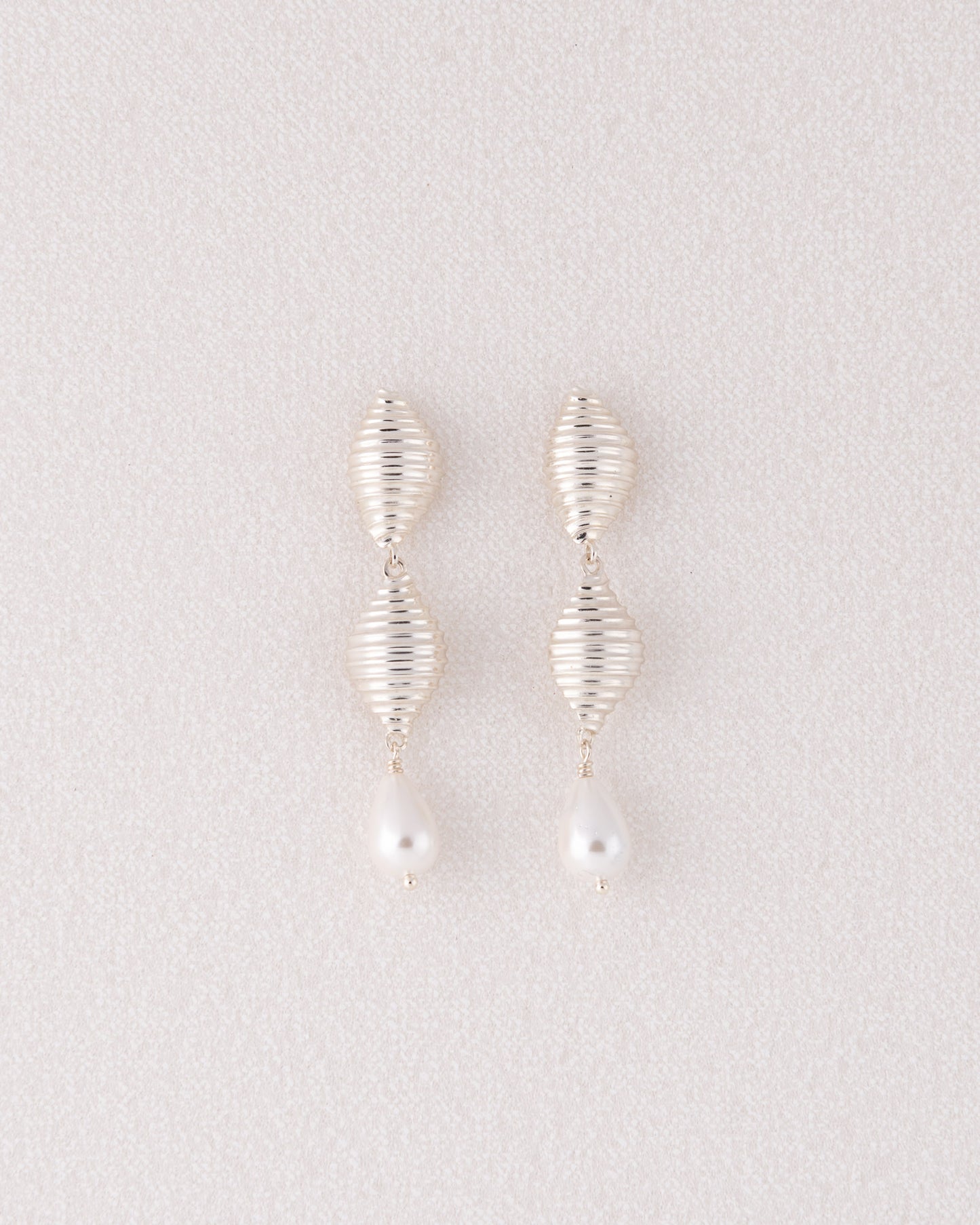 Limited edition ασημένια σκουλαρίκια Pa Shell Pearl Drop με ανάγλυφο στοιχείο κοχύλι και κρεμαστές πέρλες της ANV Jewelry.
