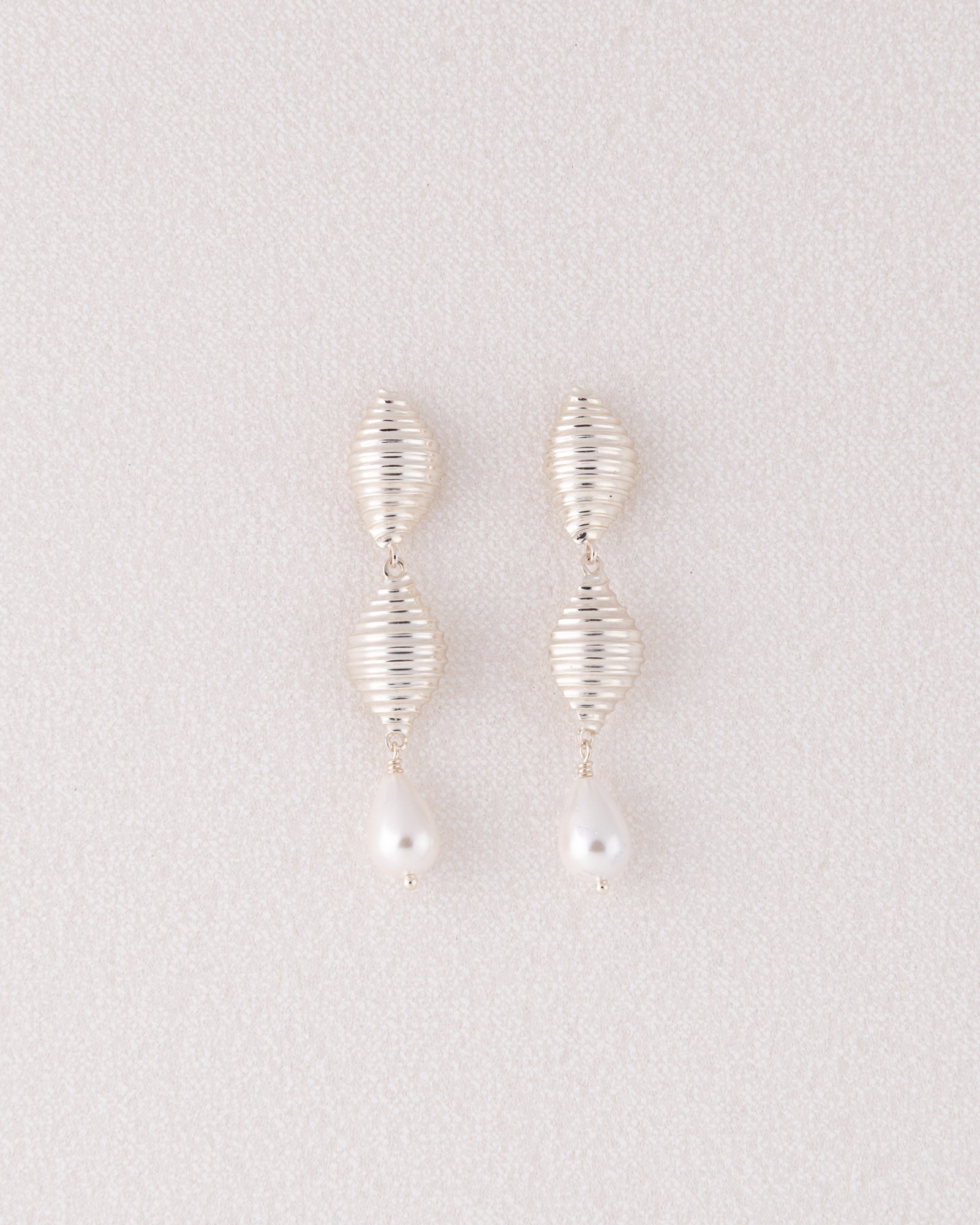 Limited edition ασημένια σκουλαρίκια Pa Shell Pearl Drop με ανάγλυφο στοιχείο κοχύλι και κρεμαστές πέρλες της ANV Jewelry.