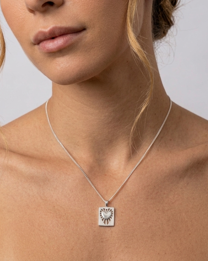 Γυναίκα που φοράει το ασημένιο κολιέ Radial Heart Talisman της ANV Jewelry από ανακυκλωμένο Ασήμι 925, συνδυάζοντας κομψότητα και μοντέρνο στυλ στην καθημερινή της εμφάνιση.